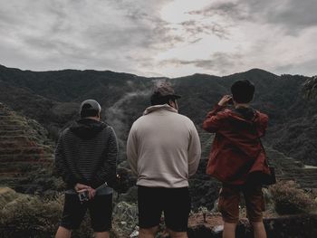 Rear view of people on mountain against sky