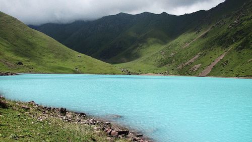 Scenic view of lake by mountains against sky