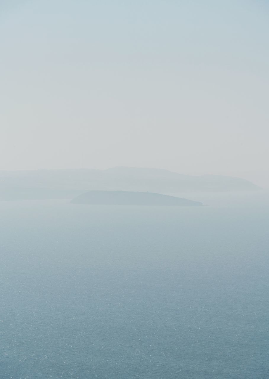 beauty in nature, scenics - nature, tranquil scene, tranquility, waterfront, sky, copy space, sea, water, fog, no people, idyllic, day, nature, non-urban scene, outdoors, remote, hazy, mountain peak, salt flat