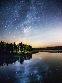 Scenic view of lake against sky at night