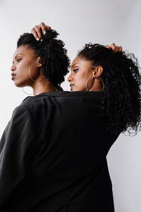 Two beautiful dark skin women wearing same jacket