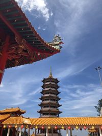 Low angle view of pagoda against cloudy sky