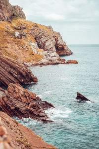 Rock formations by sea against sky