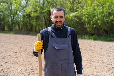 A man planting potatoes in the ground in early spring.