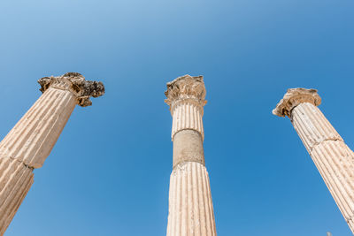 Low angle view of columns against blue sky