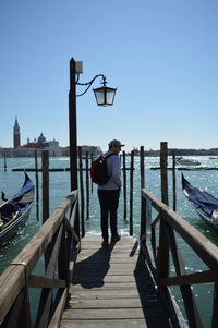 Rear view of man standing on pier