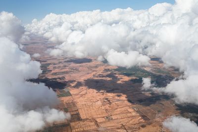 Aerial view of smoke emitting from land against sky
