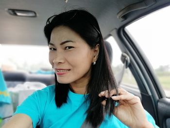 Portrait of young woman sitting in car