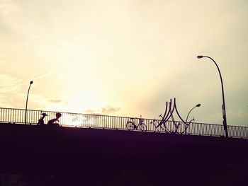 Low angle view of silhouette bridge against sky at sunset