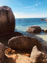 Scenic view of rocks on beach against sky