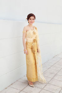 Portrait of woman standing against wall