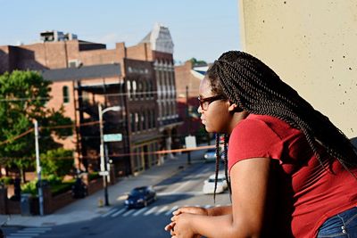 Side view of woman leaning on balcony