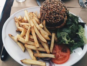 High angle view of burger and french fries in plate on table