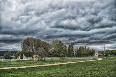 Scenic view of grassy field against cloudy sky