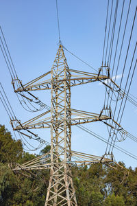 Low angle view of electricity pylon against sky