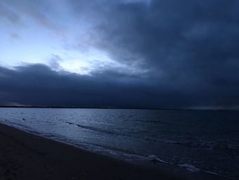 Scenic view of sea against storm clouds