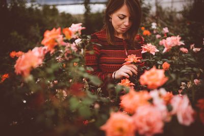 Close-up of woman with red flowers