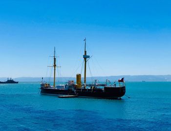 Sailboat sailing on sea against blue sky