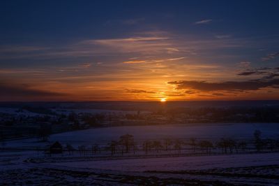 Scenic view of snow against sky during sunset