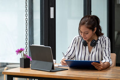 Woman looking at camera while sitting on table