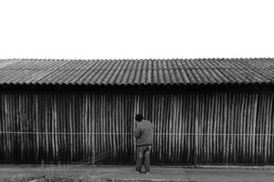 Rear view of man standing by building