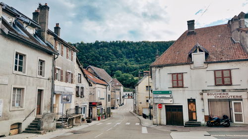 Street amidst houses and buildings against sky