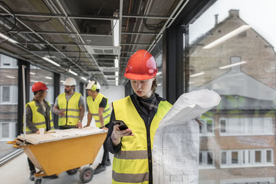 Female construction worker looking at blueprints