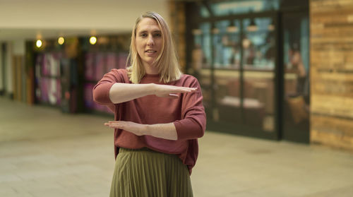 Portrait of woman gesturing while standing outdoors