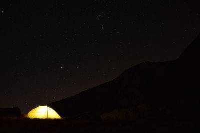 Scenic view of illuminated mountains against clear sky at night