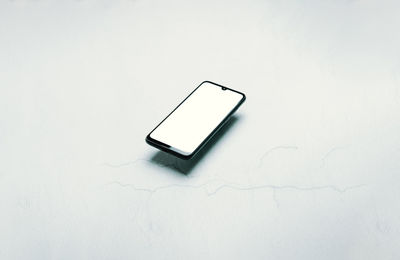 Close-up of mobile phone on white background