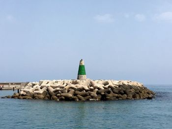 Lighthouse on tetrapods against sky