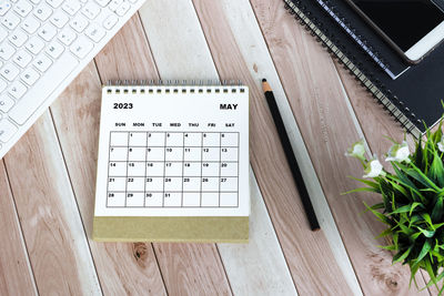 White may 2023 calendar on wooden desk .