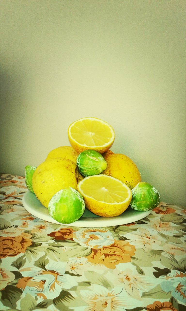 fruit, food and drink, yellow, indoors, food, freshness, still life, healthy eating, green color, table, leaf, close-up, wall - building feature, copy space, no people, lemon, home interior, orange - fruit, grape, organic
