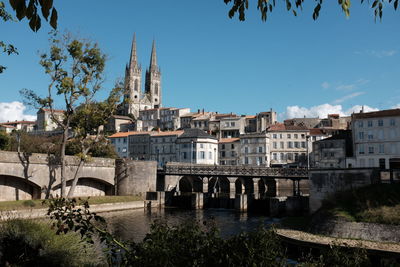 Arch bridge over river against buildings in city