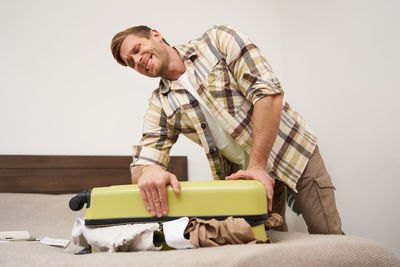 Portrait of young man sitting on sofa at home