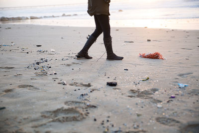 Low section of man standing on beach