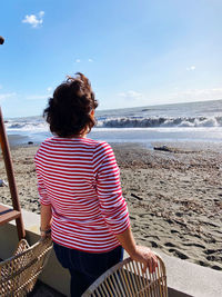 Rear view of woman sitting on beach