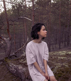 Young woman looking away in forest