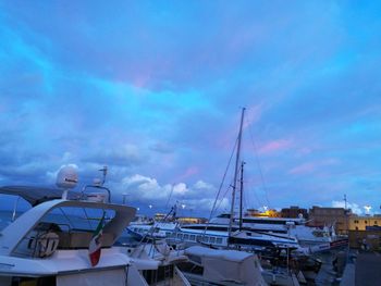 Sailboats moored at harbor