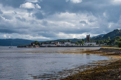 Scenic view of sea by buildings against sky