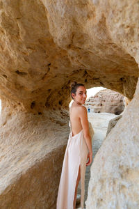Portrait of young woman standing on rock formations