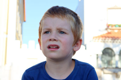 A six-year-old boy furrowed his brows and looks thoughtfully into the distance.  