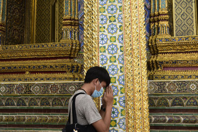 Asian men wearing a surgical mask while visiting religious sites