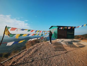 Multi colored flags hanging on clothesline against sky