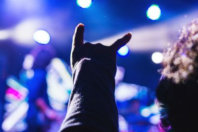 Close-up of hand on illuminated stage at night