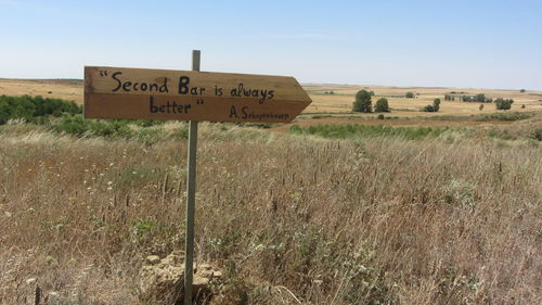 Information sign on field against clear sky