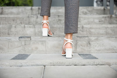 Low section of woman standing on footpath