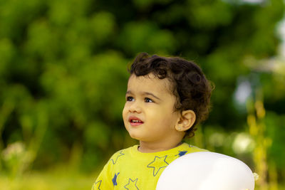 A beautiful little indian child is happy with a white balloon in his hands, asian kids