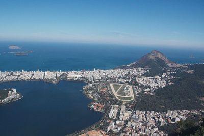 Aerial view of city by sea against sky