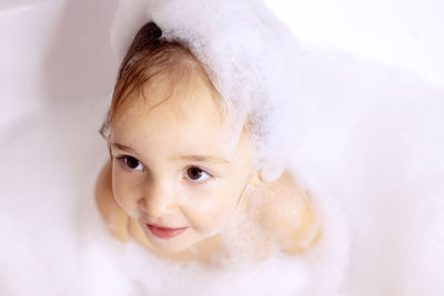 Cute girl sitting in bathtub